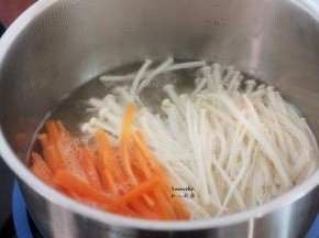 清水煮沸，放入胡萝卜、金针菇汆烫，捞出沥干水；