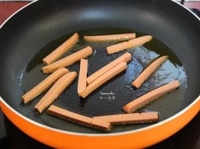热锅，倒入橄榄油，香煎火腿肠；