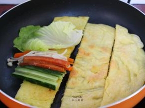 放入火腿、胡萝卜、金针菇、青瓜、生菜；花生酱，如何卷起来即可