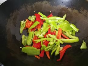 5、放入青红椒大火翻炒。