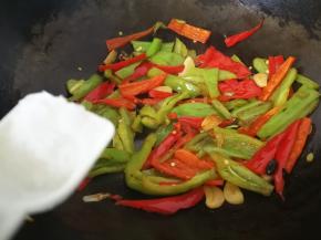 6、炒到青红椒变软后调入盐和生抽。