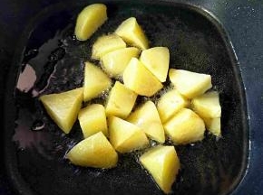 热锅热油，下土豆煸制表面焦黄盛出备用。