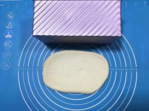 松弛完毕将面团擀成与土司盒差不多长的面片。