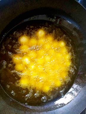 在油温达到五成热的时候，顺锅边把红薯丸子一个一个的滑入油锅中。