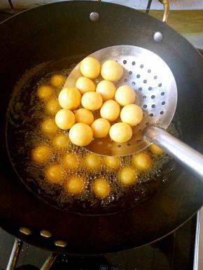 中火加热，待丸子浮到表面之后再炸两三分钟，呈现金黄色即可。