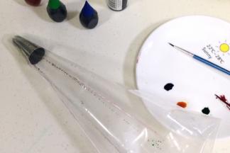 在裱花袋中装入裱花嘴，然后用描边笔蘸上色素刷在裱花袋内壁，每刷完一种色素都要清洗完再继续下一种色素的操作，以免混色。