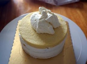 然后放入第三片蛋糕片，表面放上厚厚的淡奶油。