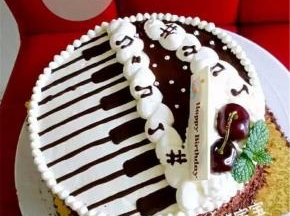 将琴键放在蛋糕表面，如图所示摆放。然后用剩余的淡奶油画出白色的钢琴裙边以及蛋糕的围边。并在白色裙边上用巧克力画出跳跃的音符，用车厘子，生日蛋糕片稍作装饰。蛋糕体四周撒上巧克力碎，完成。
