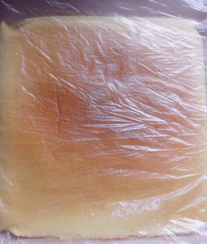 再取一个保鲜袋撕开盖在蛋糕片把蛋糕片翻过来，把正面的保鲜袋轻轻揭起，整个过程因为时间较短，蛋糕片不易粘在保鲜袋上