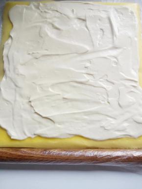 用抹刀抹平奶油，始端厚点末端薄点，用细擀面杖从保鲜袋一端反卷