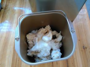 将发酵好的中种面团撕成小块放进面包机桶，再加入37克细砂糖，3克盐，15克奶粉，20克鸡蛋液，1克酵母