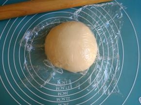 和好的面团取出，滚圆，盖上保鲜膜，静置25分钟