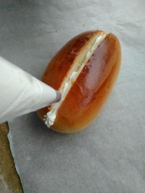 150克淡奶油加入15克细砂糖打至十分发，将打发好的淡奶油装进裱花袋内。在切开的面包内挤入奶油