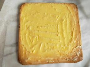 将蛋糕周围的锡纸撕开，把有虎皮花纹的一面朝下铺在一张新的油纸上，将蛋糕表面的油纸撕去，然后将虎皮蛋糕放至冷却后抹上薄薄的一层卡仕达酱备用。