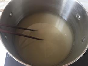 倒入清水，中火加热，用筷子搅拌白砂糖至融化