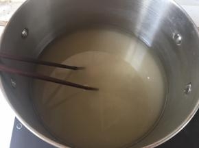 倒入清水，中火加热，用筷子搅拌白砂糖至融化