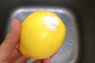 把柠檬用水冲下，取少许盐搓洗柠檬表皮。