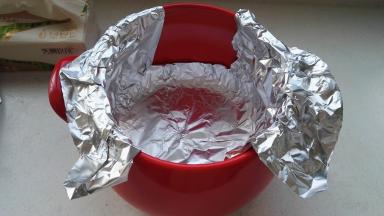 取一张锡纸放入砂锅内，内壁按下贴牢，两头延伸出锅沿外有利于蒸汽排出。