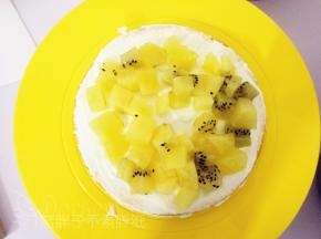 取淡奶油放在蛋糕片上，用抹刀稍微抹平整均匀放上水果丁，再盖上奶油，如此反复，直到3片蛋糕片都搞定。