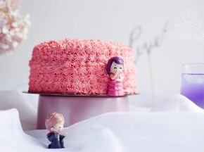 粉色淡奶油装入裱花袋，借助裱花嘴做出装饰，摆上玩偶装饰。