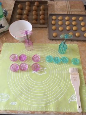 用手将饼皮按成饼状，放入包了咸蛋黄的莲蓉馅，用手慢慢将饼皮向上推，直至饼皮收口成圆球形。用羊毛刷在阳晨紫水晶月饼模模内刷上薄薄的一层糯米粉防粘。