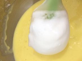 加入三分之一的蛋白糊，刮刀翻拌均匀，再将剩下的蛋白糊分二次倒入，翻拌均匀