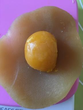 再用手压扁，中心放一颗咸蛋黄