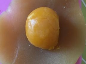 再用手压扁，中心放一颗咸蛋黄