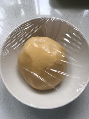 用手将面团揉捏成光滑的面团，盖上保鲜膜，静置松弛一小时