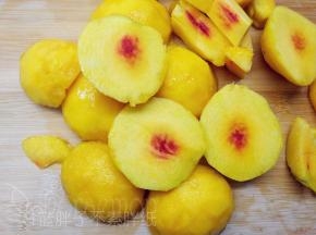 5个黄桃洗干净后削皮，对半切开。