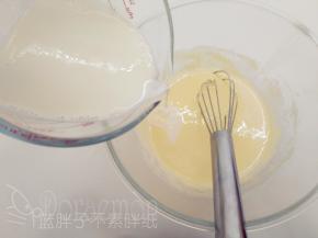 煮好的牛奶一边缓缓倒入蛋黄中，一边用手动打蛋器快速搅打。