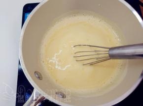 搅打均匀的蛋黄牛奶液倒回奶锅中，继续一边小火加热，一边用手动打蛋器搅打。