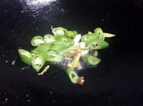 锅里留油底，把青椒姜蒜倒入炒香