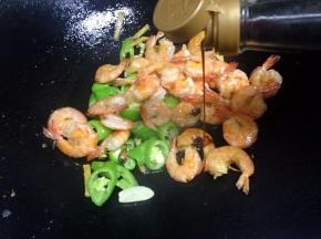 加入炸好的虾，加适量的生抽翻炒