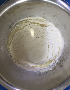 将低粉筛入蛋黄液中，用手动打蛋器搅拌成无干粉的面糊。