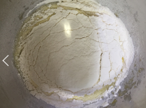 将低粉筛入蛋黄液中，用手动打蛋器搅拌成无干粉的面糊。