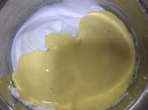 将翻拌好的蛋黄糊倒入剩余蛋白糊中，用刮刀翻拌均匀。