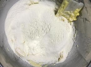 筛入低筋面粉，用刮刀搅拌均匀成无干粉的面团。