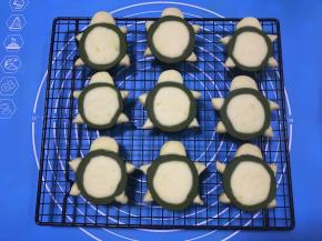 烤好的饼干放晒网上冷却，同时将黑巧克力将入裱花袋，隔热水融化。