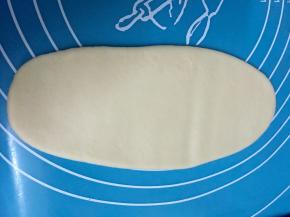 包好的酥皮用手按扁，再用擀面仗擀成图中这样，然后卷起来