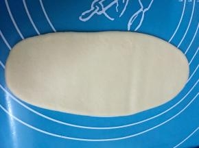 包好的酥皮用手按扁，再用擀面仗擀成图中这样，然后卷起来