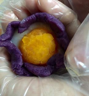 像图中一样，慢慢的将紫薯馅往上收封住蛋黄和麻薯，并且捏圆