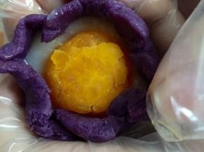 像图中一样，慢慢的将紫薯馅往上收封住蛋黄和麻薯，并且捏圆