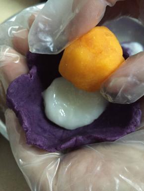 准备好紫薯馅，麻薯馅，做12个蛋黄酥我只用8个咸鸭蛋黄，把蛋黄表面洒上点酒放烤箱烤几分钟，然后把蛋黄捏碎一分成二再搓圆。先把紫薯馅按扁再放入麻薯馅，然后再放上蛋黄