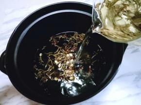 将泡好的茶水倒入锅中。