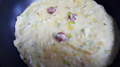 9．摇晃锅底，使面糊平均铺在锅底，加热到面糊基本上熟了，撒几滴油翻面。