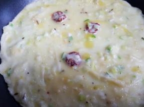 9．摇晃锅底，使面糊平均铺在锅底，加热到面糊基本上熟了，撒几滴油翻面。