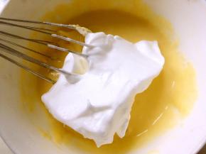 将打发好的蛋白分次加入蛋黄糊中，翻拌，注意翻拌手法要轻