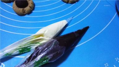 黑巧克力跟白巧克力分别装入一次性裱花袋中并隔热水融化，剪开一个细小的口