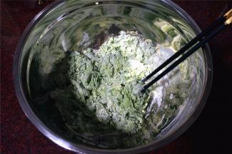 将菠菜汁倒入到面粉中，用筷子拌成絮状。